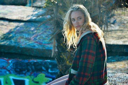 Costume design by Anette Cseri for the film The Tribes of Palos Verdes: a young woman in an oversized plaid jacket by a sea wall